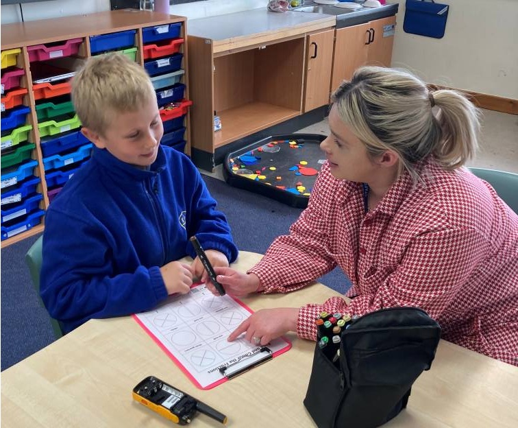 Boy and teaching assistant working on a fractions problem