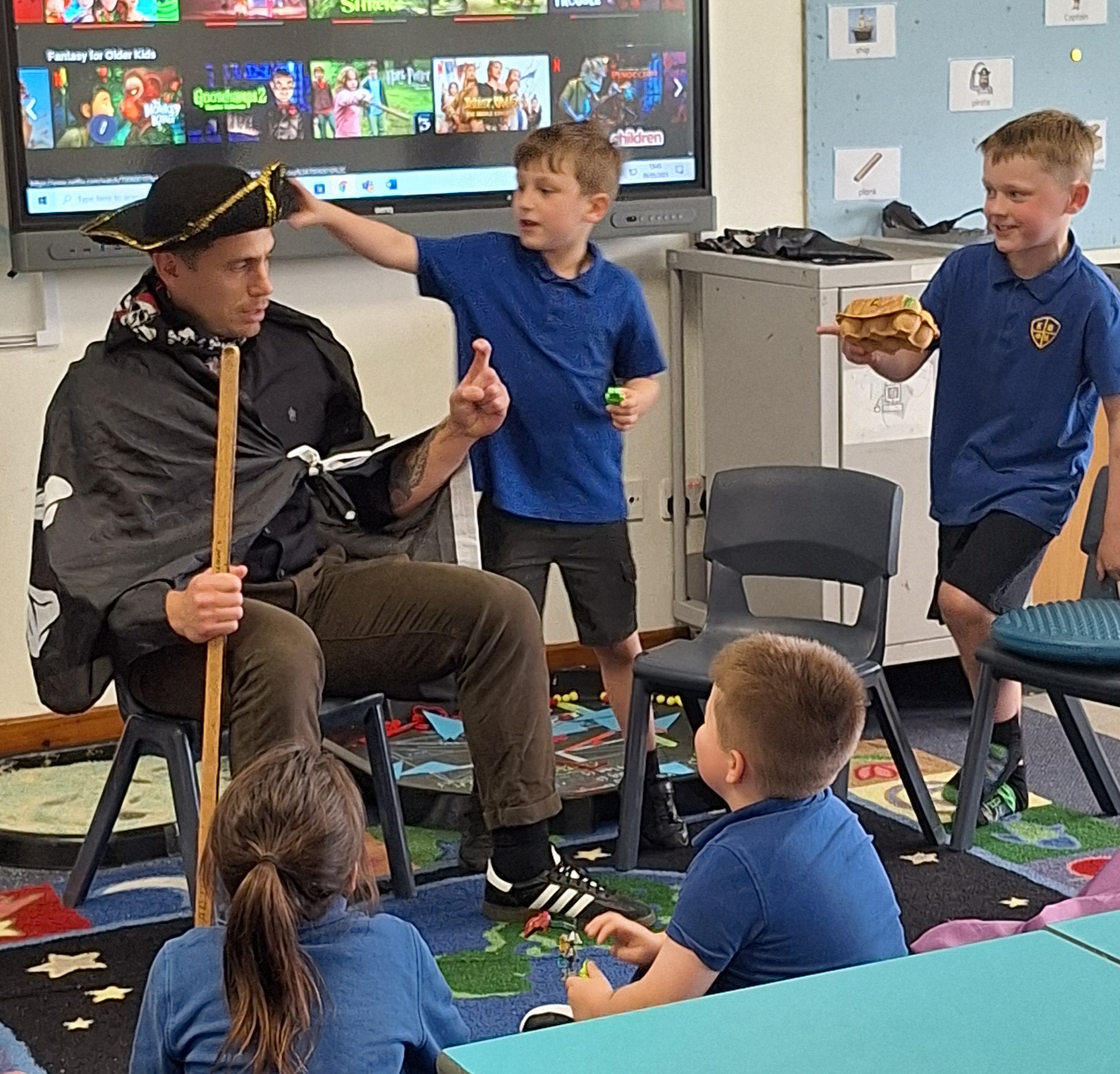 Head of School dressed as a pirate surrounded by children